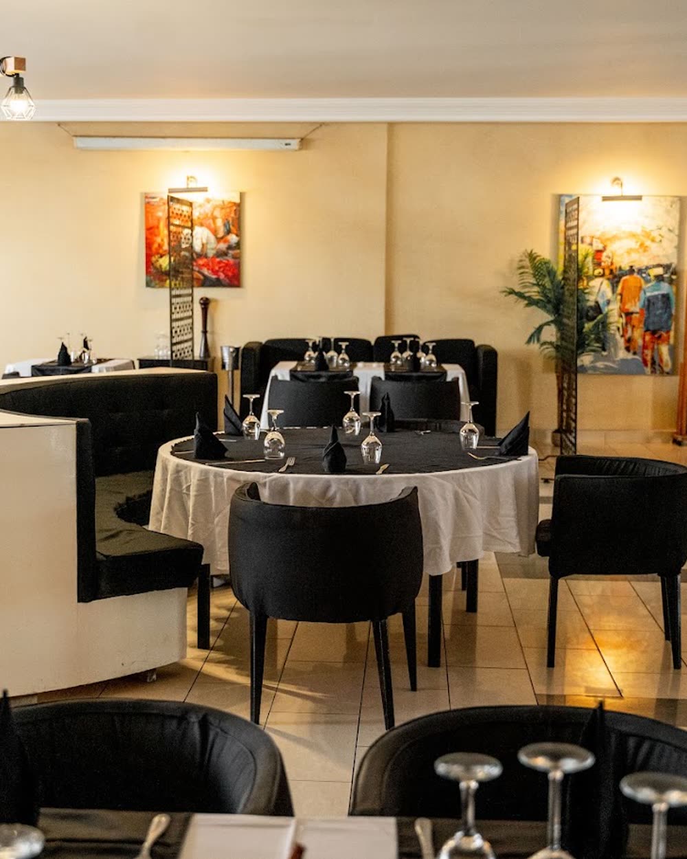 Salle du Boj dressée pour un dîner, tables rondes et œuvres d'art aux murs