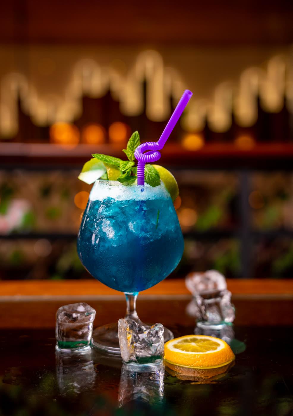 Cocktail sans alcool bleu, menthe et citron vert, servi au comptoir du Boj